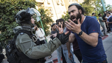 Israeli riot police try to block a Jewish right-wing man as clashes erupted between Arabs, police and Jews, in the mixed town of Lod,  Israel.