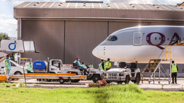 Biosecurity and airport staff in PPE gather around a Qatar Airways chartered flight carrying tennis players and staff into Melbourne on Thursday.