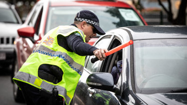 Police check cars for permits at a checkpoint in Coolangatta as the Queensland border on Friday.