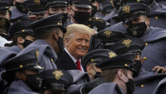 US President Donald Trump, who has refused to accept the election result, is surrounded by army cadets at a football game in New York on Saturday. 