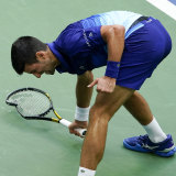 Novak Djokovic smashes his racket on the court after losing a point to Daniil Medvedev.