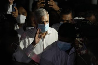 Sri Lanka’s new prime minister Ranil Wickremesinghe waves as he leaves a temple after attending religious observances in Colombo.