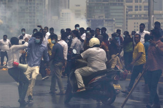Sri Lanka’s pro-government and anti-government protestors clash amid tear gas outside the president’s office in Colombo, Sri Lanka, Monday, May 9, 2022. 