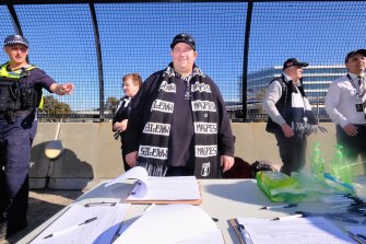 Collingwood member David Hatley taking signatures in order to spill the Magpies board.