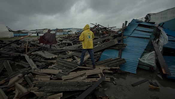 People walk through debris on the streets of Beira in Mozambique, following Idai's landfall.