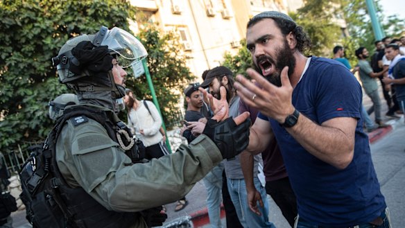 Israeli riot police try to block a Jewish right-wing man as clashes erupted between Arabs, police and Jews, in the mixed town of Lod,  Israel.
