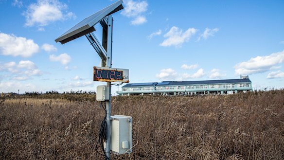A radiation-monitoring device stands in front of Ukedo Elementary School in Namie. 