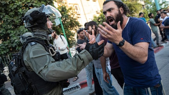 Israeli riot police try to block a Jewish right-wing man as clashes erupted between Arabs, police and Jews, in the mixed town of Lod,  Israel.