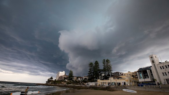 A storm rolls into Cronulla beach, where Reserve Bank research shows climate change could increase the cost of property insurance. 