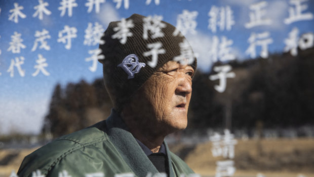 Noboru Honda, a local community leader, stands near the monument inscribed with the names of the victims of the 2011 earthquake and tsunami in Namie, Japan. 