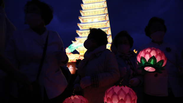 Buddhist believers hold colourful lotus lanterns as they pray around a lantern tower in the shape of a Buddhist temple pagoda on the birthday of Buddha at Gwanghwamun Plaza in Seoul, South Korea. 
