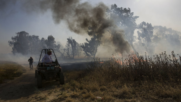 An Israeli firefighter battles a fire started by an incendiary device launched from the Gaza Strip.
