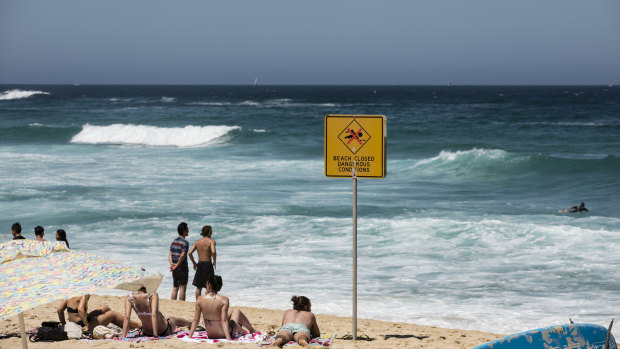 People cool off in the ocean despite the beach being closed by lifeguards due to dangerous conditions at Bronte Beach on Boxing Day.
