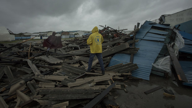 People walk through debris on the streets of Beira in Mozambique, following Idai's landfall.