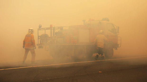 NSW RFS crews extinguish a fire that crossed the Monaro Highway, four kilometres north of Bredbo, NSW, in February this year.
