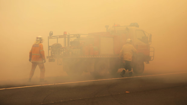 NSW RFS crews extinguish a fire that crossed the Monaro Highway, four kilometres north of Bredbo, NSW.