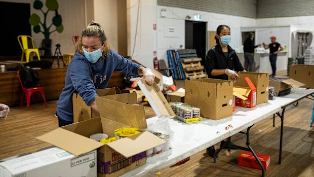 Waverley Old Boys Football Club player Anna Morrison helps pack boxes of essential goods for people in need with the Addi Road Food Pantry.