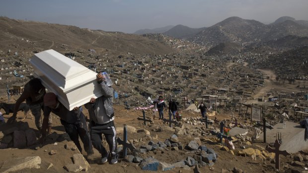 Relatives carry the coffin of their loved one during a burial in the section of the Nueva Esperanza cemetery reserved for COVID-19 cases, in the outskirts of Lima, Peru.