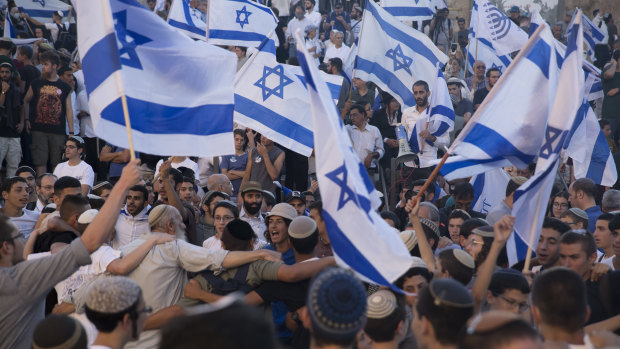 Ultra-nationalist Israelis dance with Israeli flags as they march near Damascus Gate.