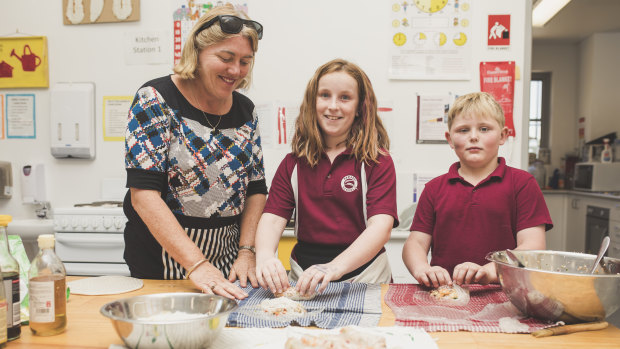 Learning support assistant Julie White, and students Scarlett Brown, 10, and Lachlan Watts, 7.