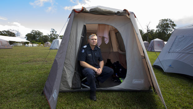 Victoria Police Acting Senior Sergeant Colin Shepherd who was deployed from the Bass Coast sits in his tent at Cann River on Wednesday.