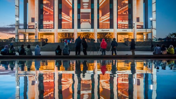 An Enlighten projection on the National Library repeated in the reflection off the pool in front of the building.