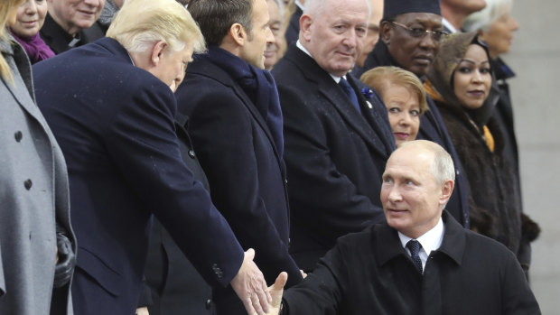 Russian President Vladimir Putin shakes hands with US President Donald Trump.