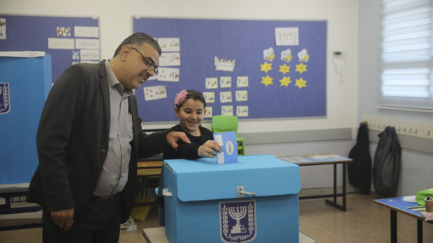 A man and his daughter vote during elections in Tamra, an Arab town in Israel.
