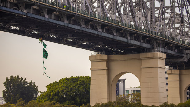 A climate activist dangles from the Story Bridge during week-long protests by Extinction Rebellion.