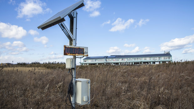 A radiation-monitoring device stands in front of Ukedo Elementary School in Namie. 