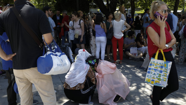 Tourist hug each other in Syntagma square after a strong earthquake hit near the Greek capital of Athens.