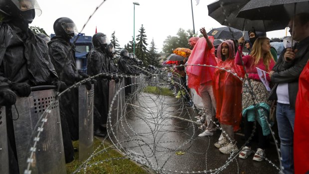Protesters argue with police standing in front of a police barricade blocking opposition rally from moving toward the Independence Palace, residence of the President Alexander Lukashenko in Minsk.