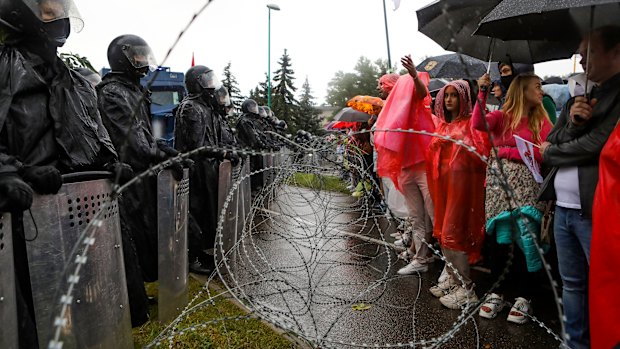 Protesters argue with police standing in front of a police barricade blocking opposition rally from moving toward the Independence Palace, residence of the President Alexander Lukashenko in Minsk.