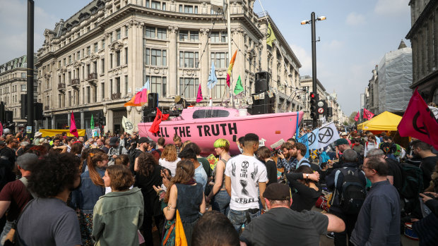 Climate activists surround a pink boat during a protest near Oxford Circus London Underground station.