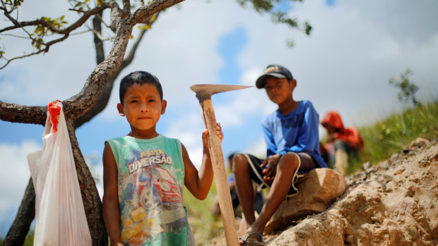 Indigenous children pose at a gold mine at the Santa Creuza community in indigenous land, Roraima state, Brazil.