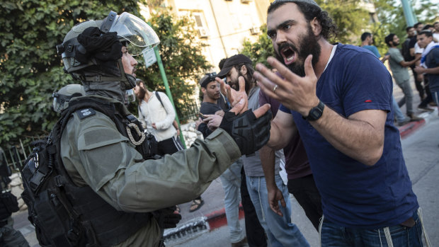 Israeli riot police try to block a Jewish right-wing man as clashes erupted between Arabs, police and Jews, in the mixed town of Lod,  Israel.