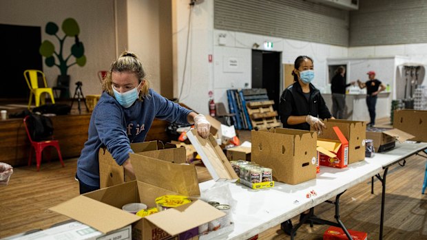 Waverley Old Boys Football Club player Anna Morrison helps pack boxes of essential goods for people in need with the Addi Road Food Pantry.