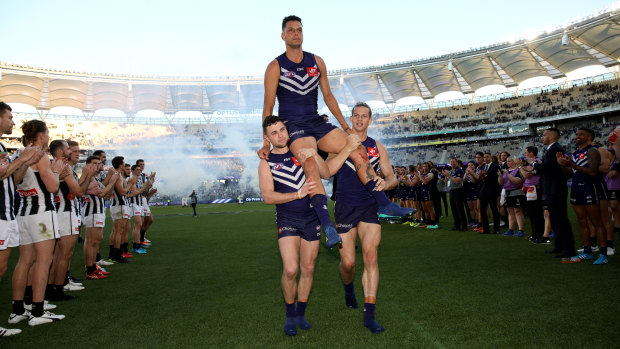 Hanging up the boots: Fremantle's Michael Johnson is chaired from the ground between a guard of honour after playing his final game, against Collinwood in round 23.