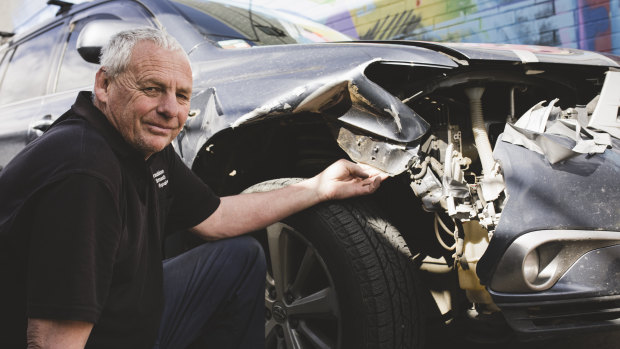 Owner of Braddon Smash Repairs, Jeff Badcoe with a car that has damage from hitting a kangaroo.