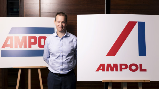 Caltex interim chief executive Matthew Halliday with the old Ampol logo (left) and the new logo (right).