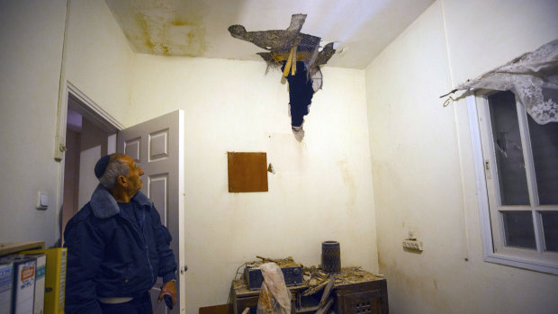 An Israeli man looks at rocket damage in a house in Sderot, southern Israel, on Monday.