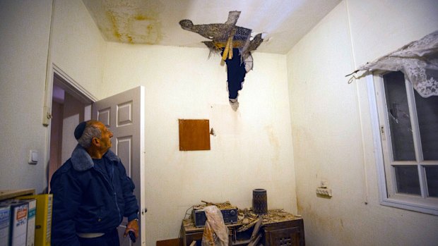 An Israeli man looks at rocket damage in a house in Sderot, southern Israel, on Monday.