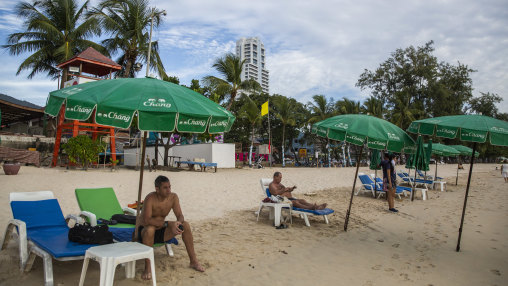 Tourists lay in lounge chairs on Patong Beach, Thailand’s most popular beach, last month.