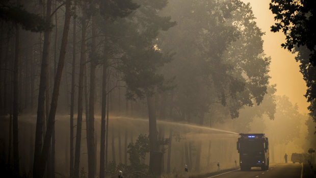 A police water cannon sprays water into a forest near Treuenbrietzen, south of Berlin.