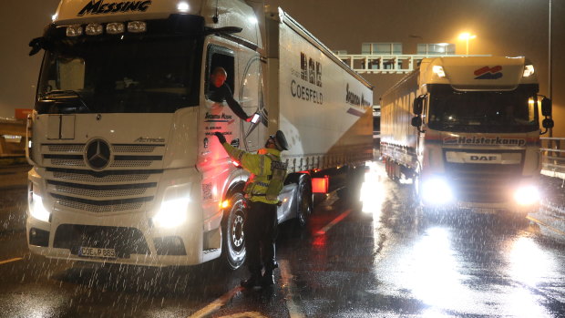 A police officer checks a truck driver's information as it rains in Dover.