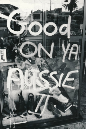 Fans graffiti the front of a shop on Lygon Street during celebrations.