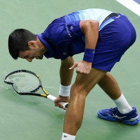 Novak Djokovic smashes his racket on the court after losing a point to Daniil Medvedev.