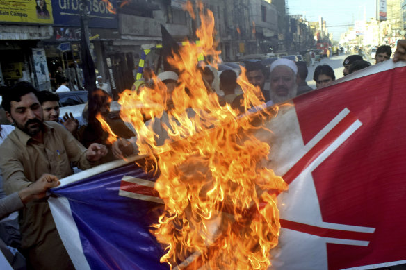 Pakistan traders burn a representation of the French flag during a protest on Monday.