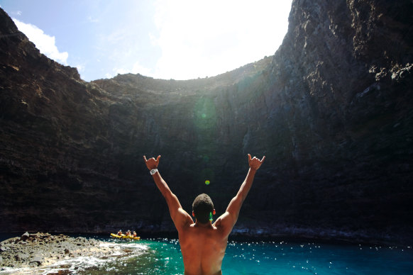 A man salutes the Pukalani Open Ceiling Cave in Kauai, Hawaii.
