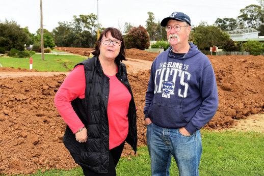 Echuca East neighbors Julie Gorledge and Peter Mitchell are on the embankment under construction in front of their property. The embankment protects the house on the other side of the street, but may leave the house in 